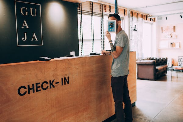 A hotel business guest doing his booking on the reception. 