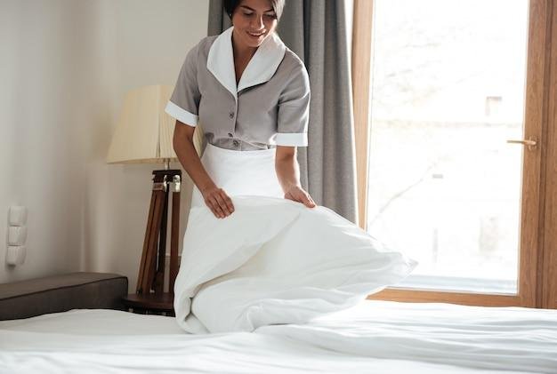 lady rom the hotel staff setting the guest bed